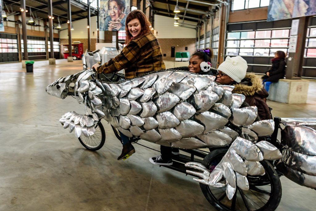A metal sculpture of an animal surrounds a bike.