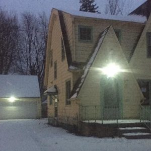 View of the house in a snow with big light on