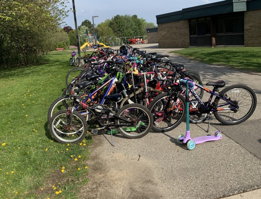 A Bike rack is overflowing with bicycles from a bike to school day event.