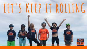 Bunch of youth are standing and celebrating during a stop on a bike ride.