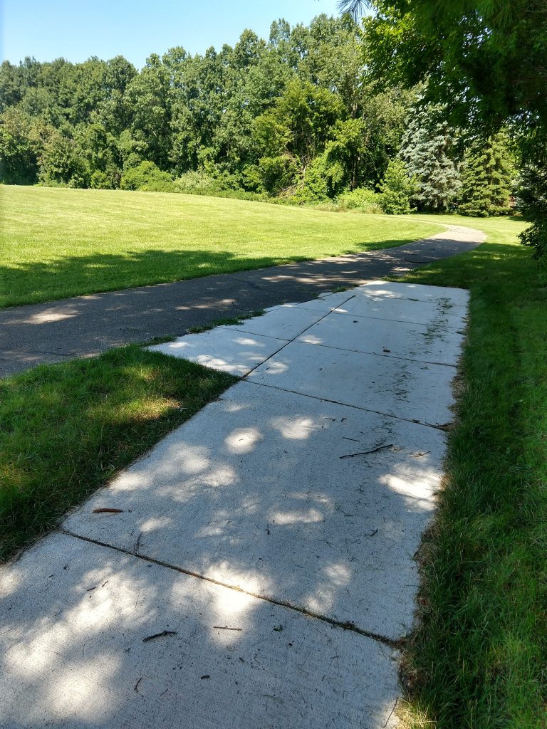 Newly constructed sidewalk segments fill a gap which once was a goat path connecting to a path.