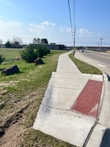 ADA ramp in foreground with sidewalk extending into background