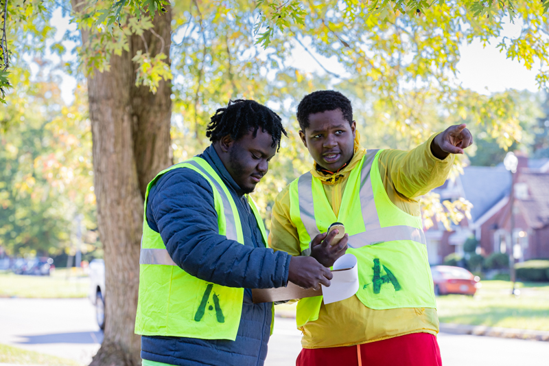 Two men wearing safety vests assessing a walking route