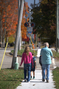 Two children and two adults approach the railroad crossing.