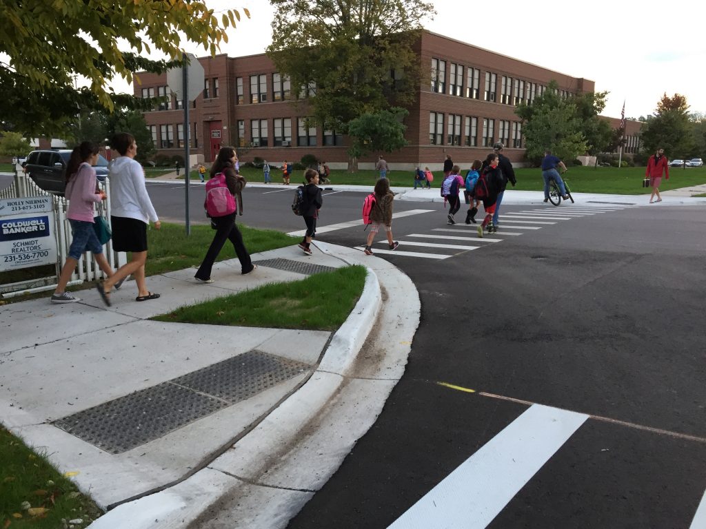 Students walk to school along new bump out and sidewalk infrastructure in East Jordan