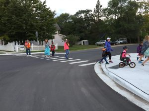 A crossing guard assisting students and parents along route on Walk and Roll to School Day.