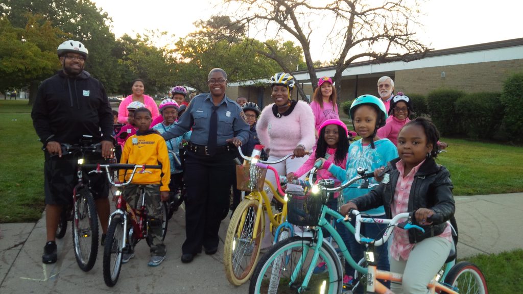 students and adults on bike gather together with SRTS coordinator for Bike to School Day event in Detroit