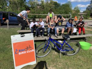 Crim Bike Club students gather before a lesson on bleachers
