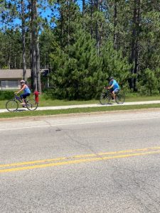 two cyclists are using the sidewalk alongside the road