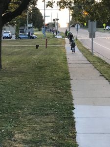 Students walking and biking along a sidewalk