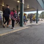 Walking school bus of students and parents walk from a remote drop location.