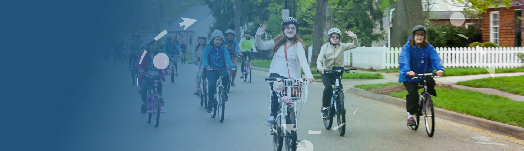 Group of kids and one parent are bicycling while wearing helmet