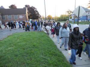 Large group of walking school bus participants walk together from a church meet up spot 