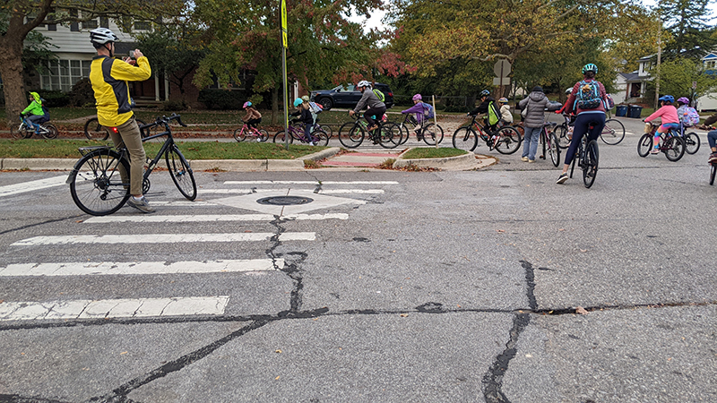 Group of families walking down a sidewalk on the way to school